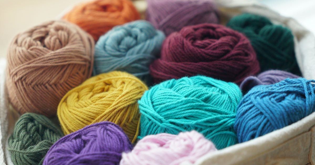 Vários novelos de lã de cores vibrantes e variadas.