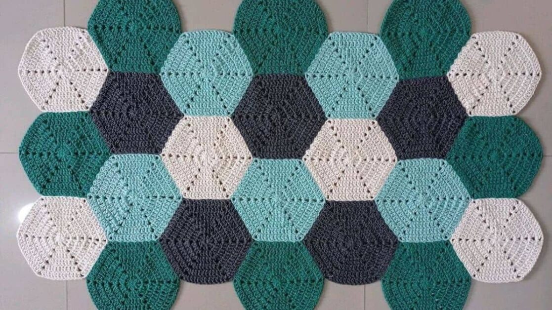 Tapete de crochê com vários hexágonos coloridos unidos.